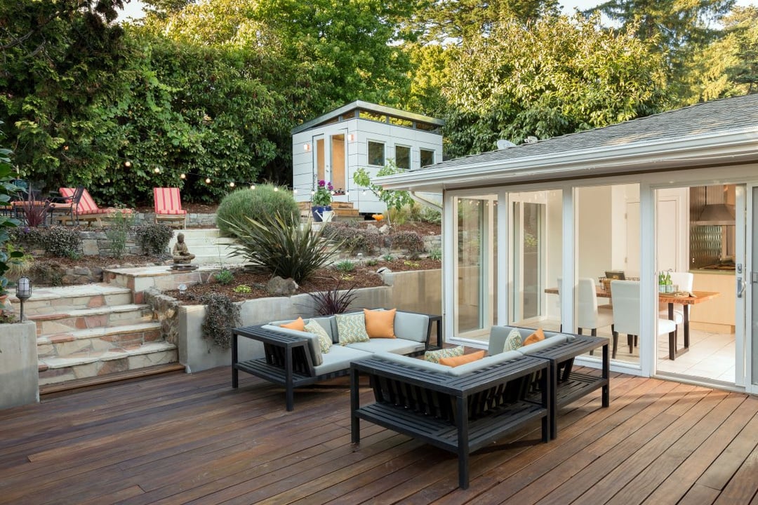 decking with seating in a garden behind a house