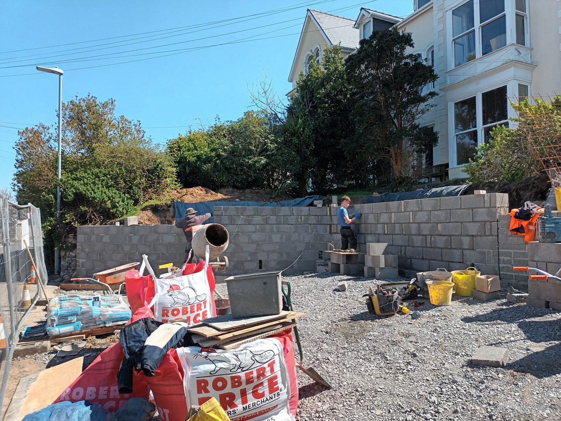 A young man building a wall out of bricks